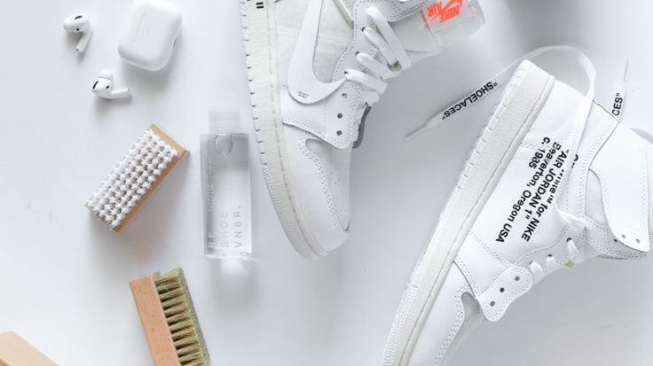 A man using a cloth on a sneaker for sneaker maintenance